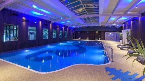 a large swimming pool in a hotel with purple lighting at The Riverside Park Hotel in Enniscorthy