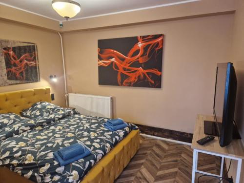 Schlafzimmer mit einem Bett und einem Flachbild-TV in der Unterkunft WILLA VASCO NAWIGATOR in Rewa