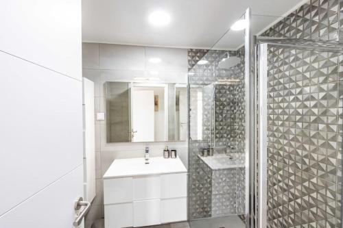 a white bathroom with a sink and a shower at Vista MarVilla Eira Nova in Porto Covo