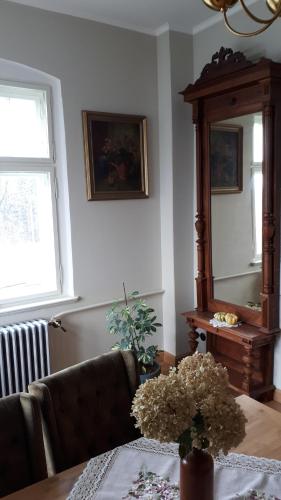 een woonkamer met een bank, een tafel en een spiegel bij Willa "Pod Bukiem" in Złoty Stok