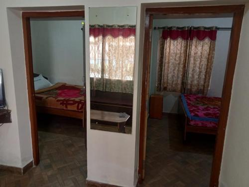 a room with a bedroom with a bed and a mirror at Royal Queen Residency in Ooty