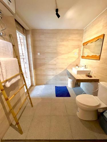 a bathroom with a toilet and a sink at ila gaia Bali in Canggu