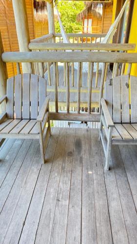 2 bancos de madera sentados en un porche en Bibis house, en Porto Seguro