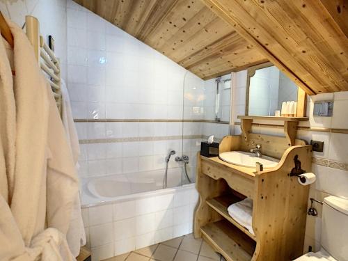 une salle de bain avec un lavabo et une baignoire dans l'établissement Chez Arsene - appartement - 10 pers - proche piste, aux Gets