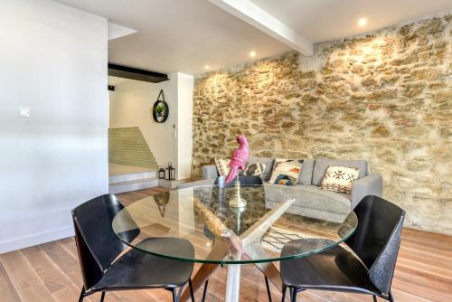 a living room with a glass table and chairs at le maquens - parking gratuit - wifi - netflix in Carcassonne