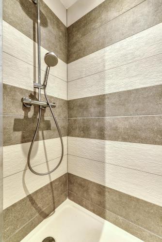 a shower with a hose in a bathroom at le maquens - parking gratuit - wifi - netflix in Carcassonne