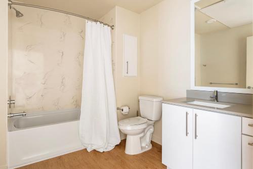 La salle de bains est pourvue de toilettes, d'une baignoire et d'un lavabo. dans l'établissement Blueground Oakland gym lounge nr restaurants SFO-1681, à Oakland