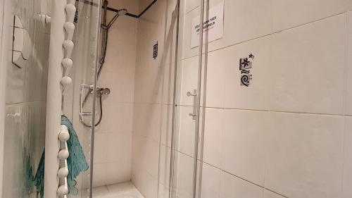 une salle de bain avec une douche avec une porte vitrée dans l'établissement Clos 28 - appartement - 6pers - proche centre, aux Gets