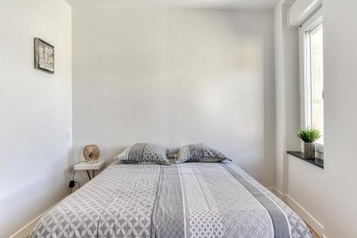 a bedroom with a bed in a white room at le maquens - parking gratuit - wifi - netflix in Carcassonne