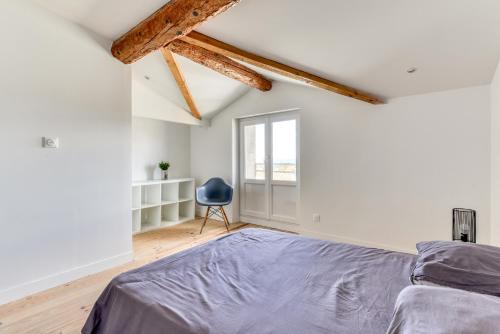 a bedroom with a bed and a blue chair at le maquens - parking gratuit - wifi - netflix in Carcassonne