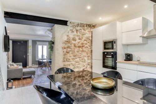 a kitchen and living room with a stone wall at le maquens - parking gratuit - wifi - netflix in Carcassonne