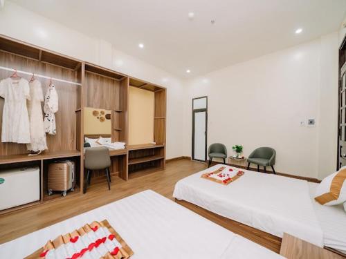 sypialnia z 2 łóżkami i biurkiem oraz pokój w obiekcie Gia Cat Long Hotel And Travel w Hajfong