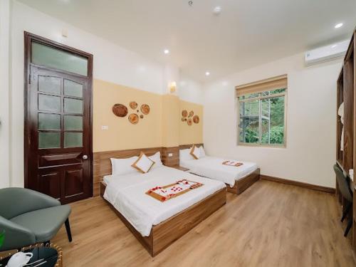 a hotel room with two beds and a window at Gia Cat Long Hotel And Travel in Hai Phong