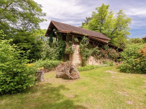 een stenen huis met een boomstronk in de tuin bij Cottage in Les Eyzies De Tayac Sireuil with pool in Meyrals