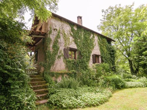 una casa vieja cubierta de hiedra con escaleras que conducen a ella en Cottage in Les Eyzies De Tayac Sireuil with pool, en Meyrals
