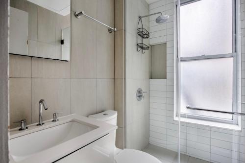 La salle de bains est pourvue d'une baignoire, de toilettes et d'une douche. dans l'établissement Classic LES 1br w wd nr SoHo NYC-646, à New York