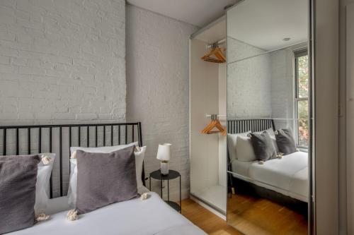 a bedroom with two beds and a mirror at Classic LES 1br w wd nr SoHo NYC-646 in New York