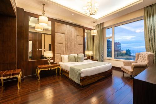 una camera con un letto e una sedia e una finestra di The Orchid Hotel Shimla a Shimla