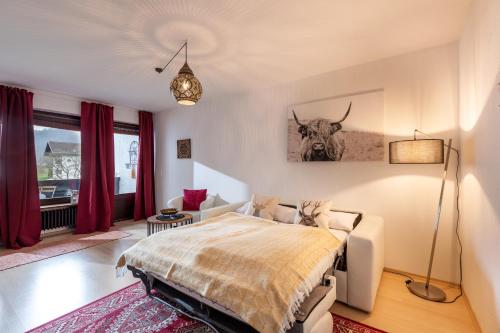 una camera con un letto e una mucca sul muro di Ferienwohnung Kranzhornblick - Alpenmagie Suites a Oberaudorf