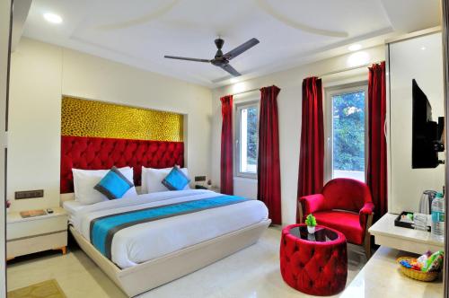 Hotel Delhi Fab - Near Connaught Place في نيودلهي: غرفة نوم بسرير كبير و اللوح الأمامي الأحمر
