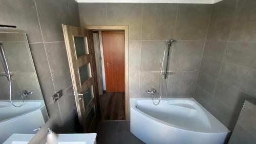 a bathroom with two sinks and a tub and a toilet at Restaurace Pyramida in Karlovy Vary