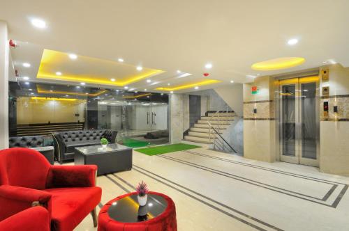 新德里的住宿－Hotel Delhi Fab - Near Connaught Place，客厅配有红色椅子和沙发