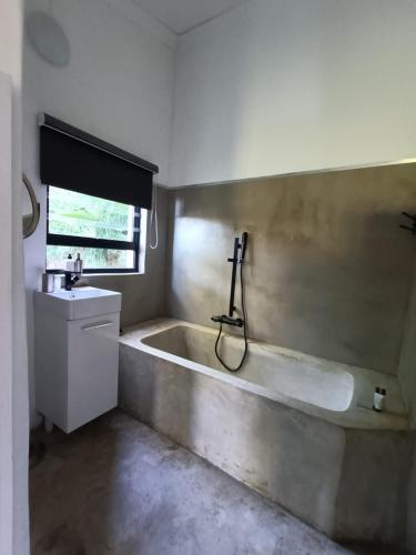a bathroom with a bath tub and a sink at Lieu De Grace in Johannesburg