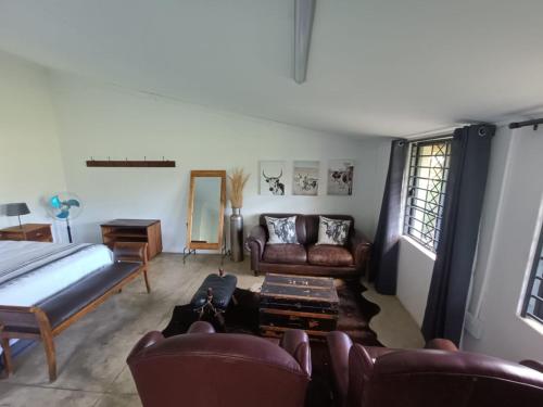 uma sala de estar com uma cama e um sofá em Lieu De Grace em Joanesburgo