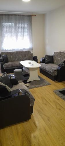 a living room with a white table and couches at Stan na dan M&M in Lug