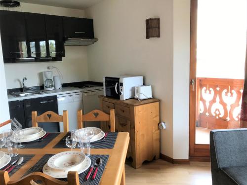 une cuisine avec une table avec des assiettes et des verres dessus dans l'établissement Le Moabi- appartement- 4pers-centre station, aux Gets