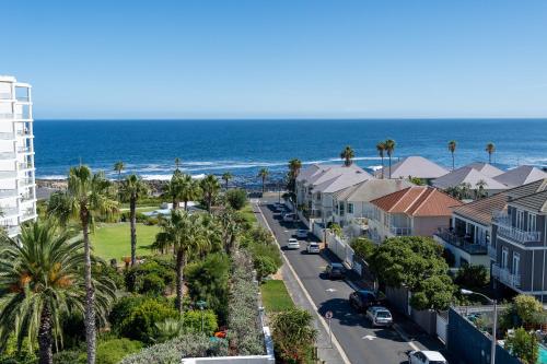 a street in front of a beach with palm trees at President Hotel in Cape Town