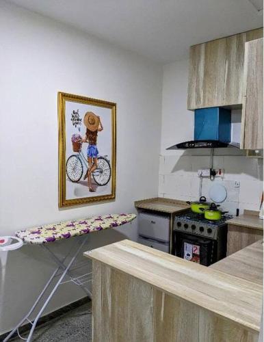 a kitchen with a picture of a person on a bike on the wall at Mars Room (Wi-Fi and smart TV) Ikoyi in Lagos