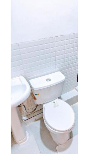a bathroom with a white toilet and a sink at Mars Room (Wi-Fi and smart TV) Ikoyi in Lagos