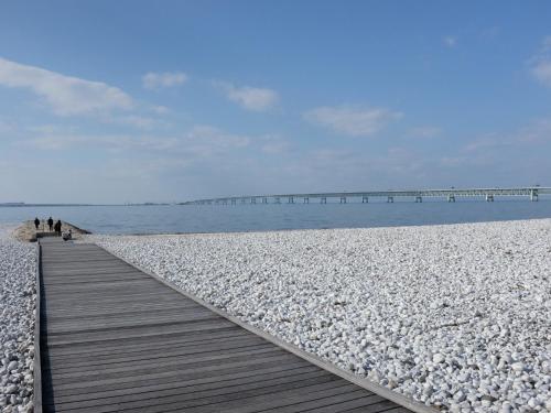 a boardwalk on a beach with a pier in the water at EZ HOTEL Kansai Airport Seaside in Izumi-Sano