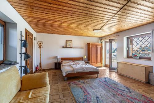 een slaapkamer met een bed en een woonkamer bij Fuchsbau Ferienwohnung am Chiemsee in Seeon-Seebruck