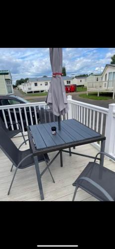a table and chair on a porch with a dress on it at Cosy static caravan, hunstanton in New Hunstanton