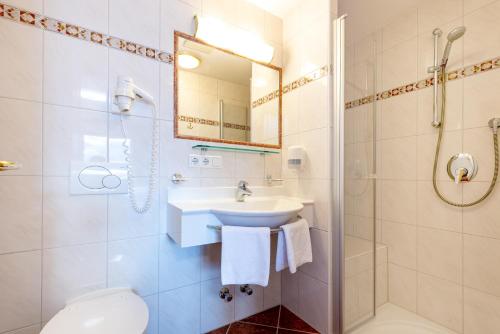 uma casa de banho com um lavatório, um WC e um espelho. em Astegg, Alpengasthof em Finkenberg