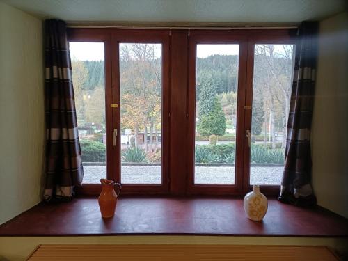 a window with three vases sitting on a window sill at Forest 104 in Vielsalm