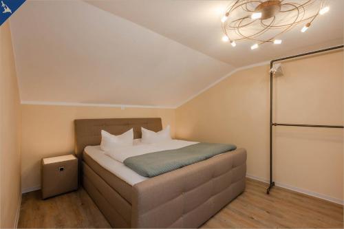 ein kleines Schlafzimmer mit einem Bett mit einer Decke in der Unterkunft Ferienhaus Becker Ferienwohnung Brücke in Heringsdorf