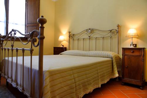 a bedroom with a bed and a table with two lamps at Podere Del Griccia in Civitella in Val di Chiana