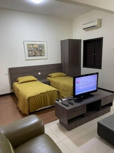 a room with two beds and a tv and a couch at Bayou Bliss@Bayou Lagoon in Ayer Keroh