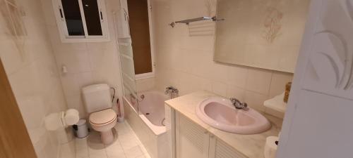 a white bathroom with a sink and a toilet at Miramar Serveis - Apartamento Rosita Parking y A/C in Cambrils