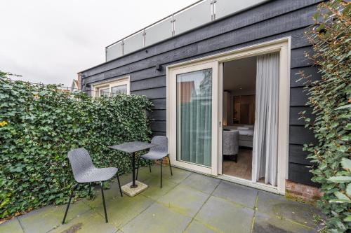 a patio with chairs and a table next to a building at Zeayou Zeeland - Studio's Zuidstraat 1 in Domburg