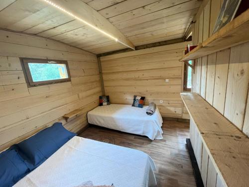 a room with two beds in a log cabin at La Cabane de Mercone MELU in Corte