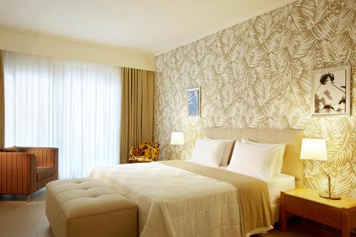 - une chambre avec un grand lit et une chaise dans l'établissement Afitis Boutique Hotel, à Afytos