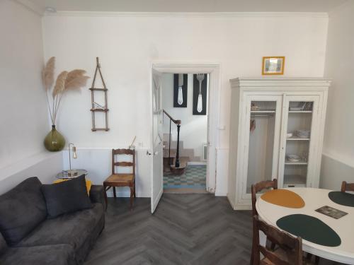 a living room with a couch and a table at Gîte Le Prieur é - COEUR DE BOURG - maison 48 M2 in Creully