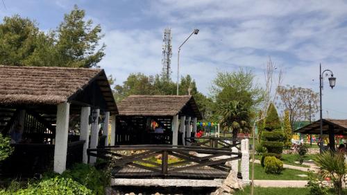 a wooden building with a bridge in a park at Agroturizem Eldi in Fier
