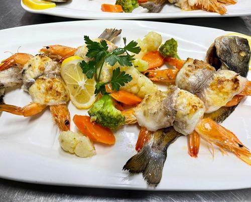 a white plate of food with shrimp and vegetables at Agroturizem Eldi in Fier