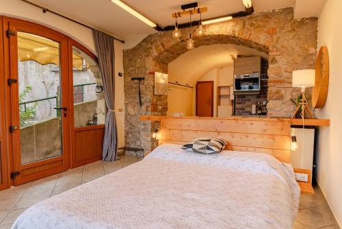 a bedroom with a large bed and a stone wall at Studio with private garden by GardaDoma in Brenzone sul Garda