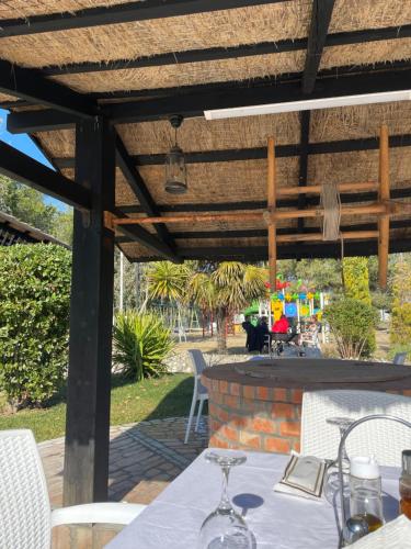 a patio with a table and a wooden pergola at Agroturizem Eldi in Fier